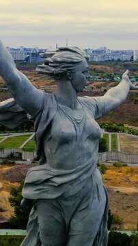Vertical video. Volgograd, Russia. The Motherland Calls colossal concrete sculpture with outstretched arm and raised sword, Drone footage over Mamayev Kurgan memorial complex on an overcast evening. 