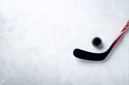 Hockey stick and puck on a clean ice rink surface, top view