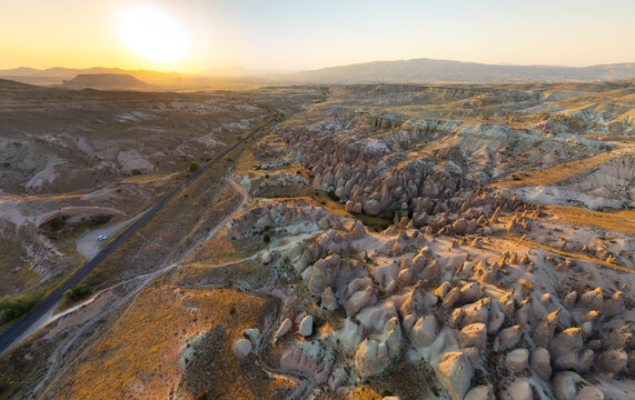 Goreme, Nevsehir, Turkey. Wide panoramic aerial view of Devrent Valley (Imagination Valley) at sunset. Unique fairy chimneys and rock formations in warm golden light. Aerial view.