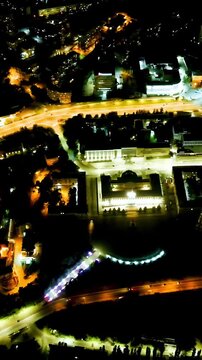 Vertical video. Lipetsk, Russia. Night city lights over the historic center, Drone footage of illuminated streets, traffic arteries, and distinctive circular building after sunset. Drone footage. Ric