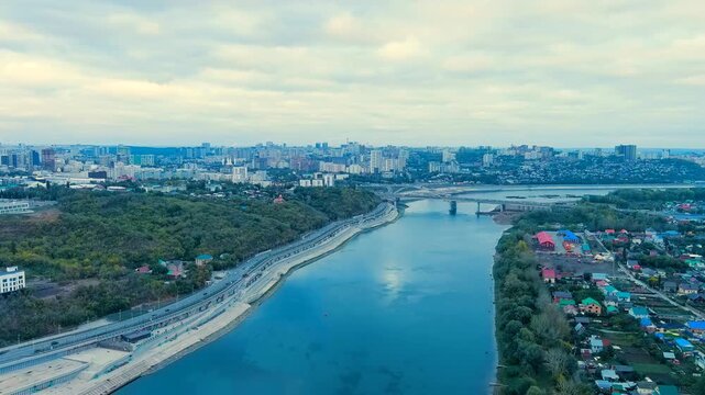 Ufa, Russia. Belsky Bridge spanning the Belaya River, steel half-through arch structure with parallel beam span, aerial panoramic view over the waterway and urban skyline. Drone footage