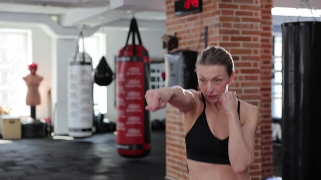 Woman boxer shadow boxing in gym
