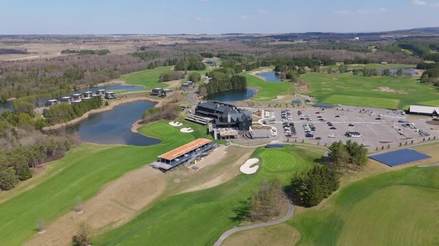 TPC Toronto at Osprey Valley showcasing the golf course, clubhouse, and parking area. Ideal for real estate marketing or tourism promotions.