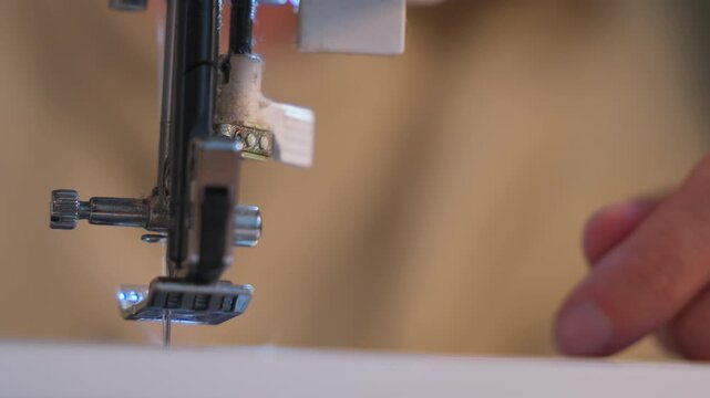 Woman threading a sewing machine. Extreme close up, slowmotion.