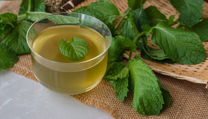 A glass of mint tea with mint leaves on the table © hunterpic2013