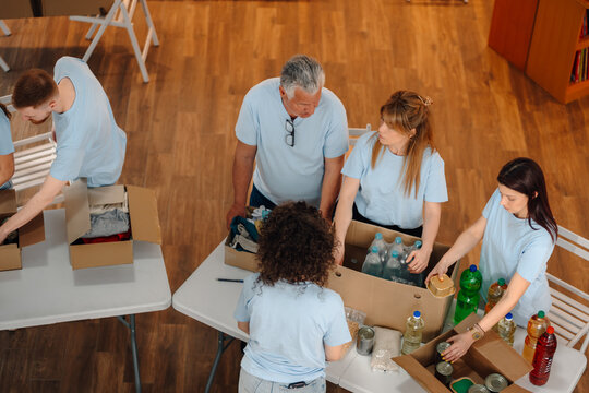 Volunteers packing donation boxes with food and clothes