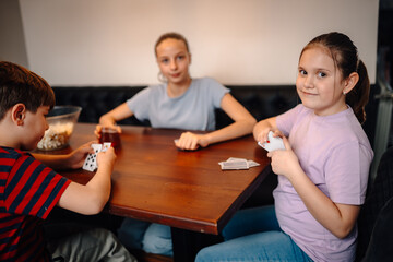 Fototapeta premium Children playing cards having family fun indoors