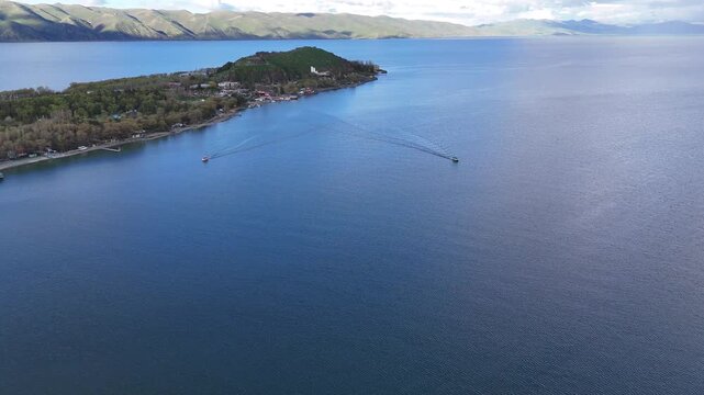 4K Drone Aerial View of Mountain Lake With Two Floating Boats and Scenic Shoreline.