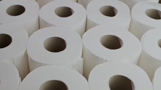 Rows of fresh white toilet paper rolls organized in neat grid, close up footage.