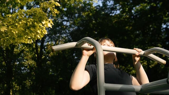 Individual doing pull ups on outdoor bars