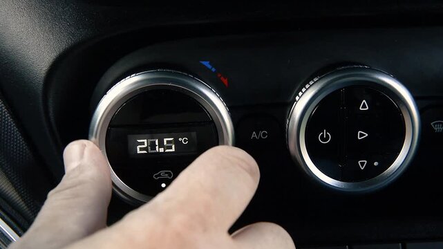 Driver turning on car climate control system
