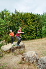 Teenager boy jumping between rocks during countryside adventure © Cavan