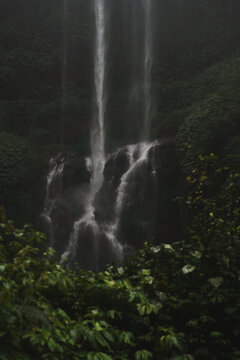 Dark dramatic triple waterfall cascading in tropical rainforest, Bali