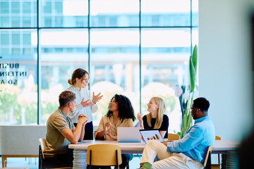 Diverse business professionals brainstorming and discussing project data during a corporate meeting...