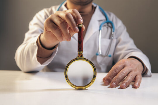 Doctor holding a magnifying glass, close-up, selective focus