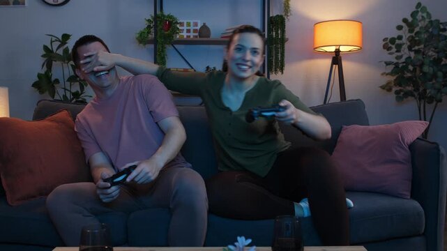 Playful couple cheating while playing video games