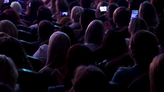 People in the auditorium are watching a concert