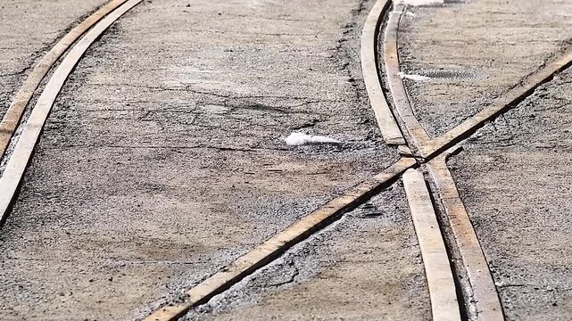 Empty tram crossing on an asphalt road, visible in perspective