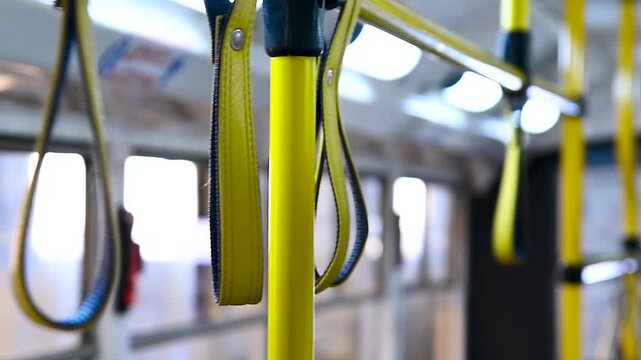 Close-up of the handles for a standing passenger inside the bus