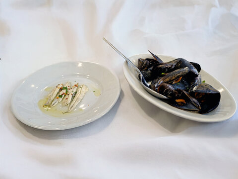 Antipasto di pesce con alici marinate e impepata di cozze su tavola elegante 0321