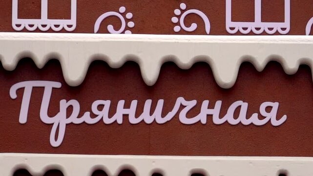 Moscow, December 30 2025, Brown sign with white icing drips. White cursive text: Gingerbread. Ornate window motifs and hearts decorate the sign. Festive shopfronts use this style for winter holidays