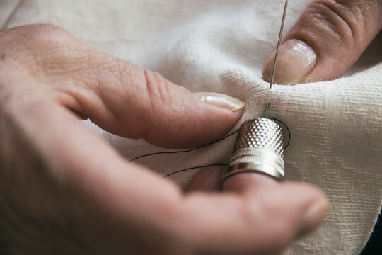 Woman with a thimble sewing