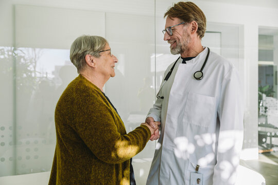 Doctor and senior patient in medical practice shaking hands