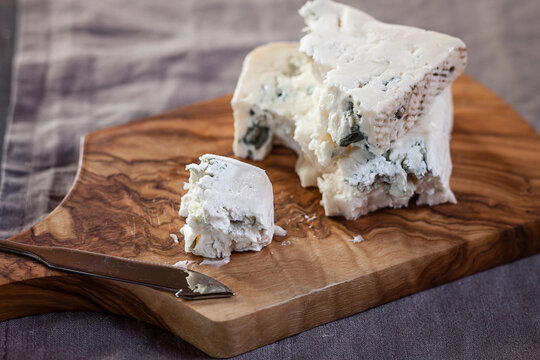 Pieces of gorgonzola cheese on chopping board