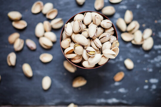 Bowl of roasted and salted pistachios on slate
