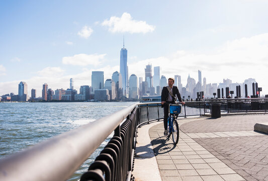 USA, man on bicycle at New Jersey waterfront with view to Manhattan