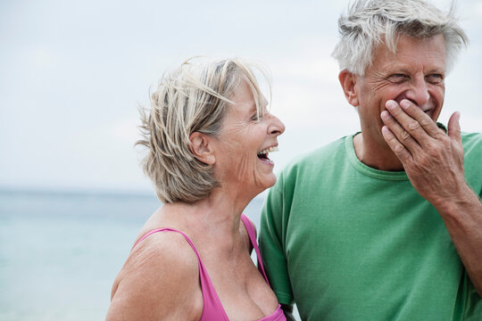 Spain, Senior couple smiling on beach