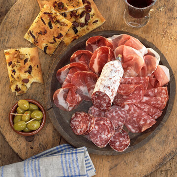 Sliced salami and ham with foccaccia and olives