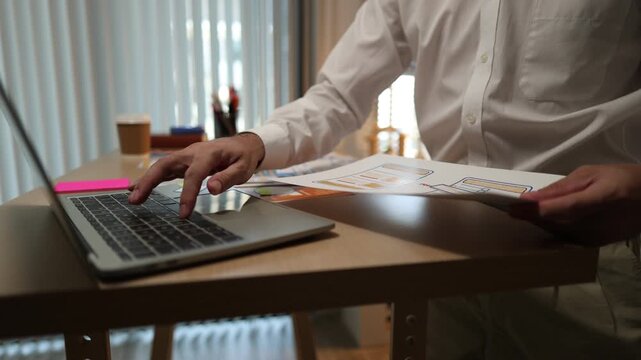 Business professional reviewing mobile application wireframes and user interface layouts while planning digital product development, UX design strategy, software features, and workflow optimization.