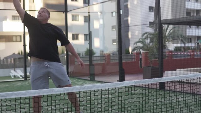 Close-up, man with racket practicing hitting balls at the net, Concept game of padel tennis