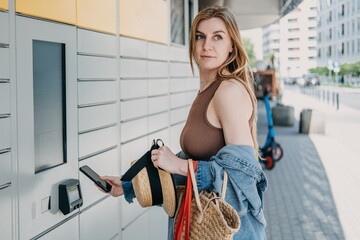 Woman holds smartphone near automated package terminal and shopping bags. Smart city retail infrastructure, urban technology integration service, automated neighborhood locker hub. © irissca