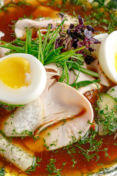 Savory soup with chicken soft boiled egg and herbs