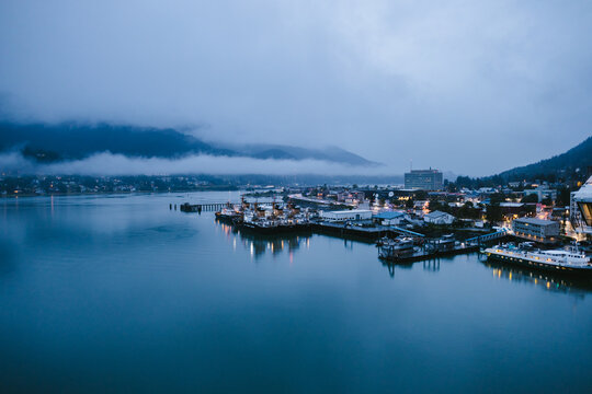 Small Alaskan town at night on the water with clouds and mountains