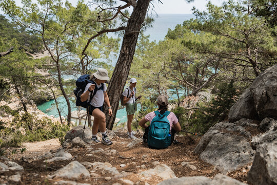 Three women hiking on a scenic trail by the sea