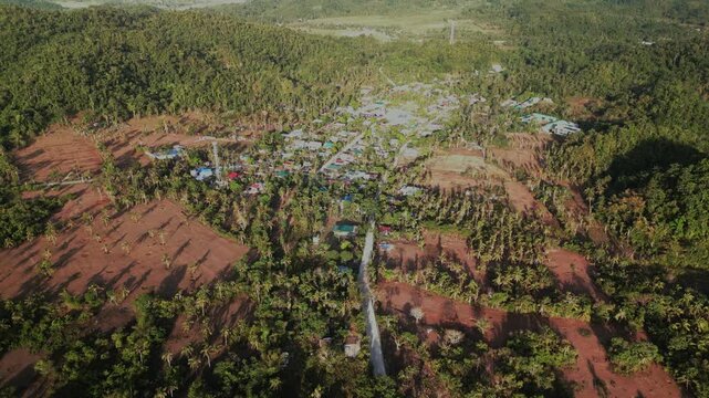 Aerial pullback over Hawan Grande in Virac, Catanduanes, revealing a rural barangay area with homes, coconut groves, and tropical terrain