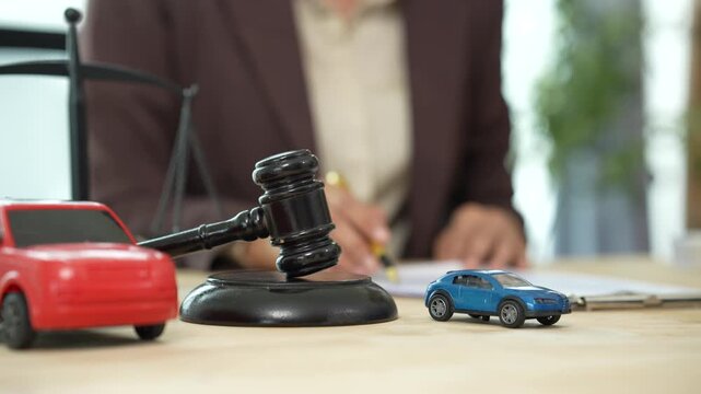 Judge&rsquo;s gavel above a model car, symbolizing auto insurance claims, legal disputes, vehicle liability, compensation, and transportation law.