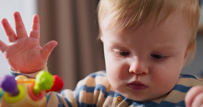 Curious toddler intently exploring colorful interactive toy, developing fine motor skills and cognitive abilities through focused play and tactile engagement indoors