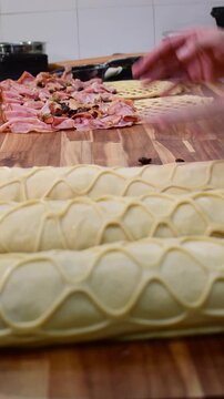Close up vertical view of hands rolling decorative dough pan de jamon