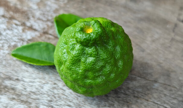 Fresh kaffir lime fruit on a wooden floor.