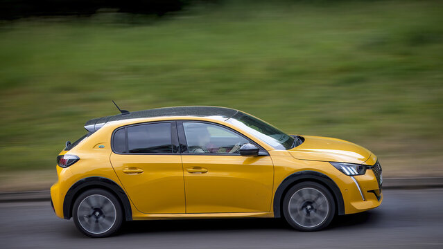 Milton Keynes,Bucks,UK - May 28th:2022 yellow Peugeot 208 gt electric  car driving on a British road