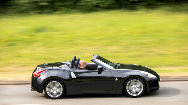 Milton Keynes,Bucks,UK - May 28th:  2011 black Nissan 370z convertible car driving on a British road