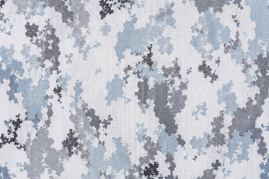 Overhead macro of seamless Arctic snow camouflage ripstop fabric with white, ice blue, and charcoal textile background