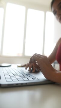 Detailed shot of hands carefully interacting with laptop keys and glass