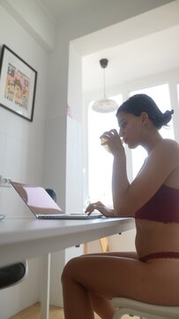 Young lady takes break enjoying her beverage while working remotely