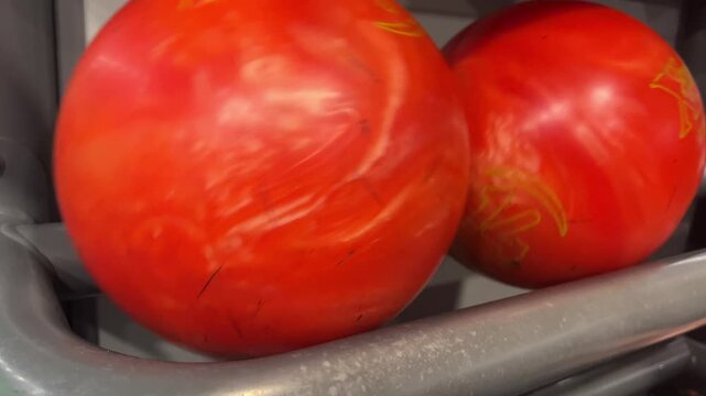 Red bowling ball in ball return rack, close up bowling alley detail