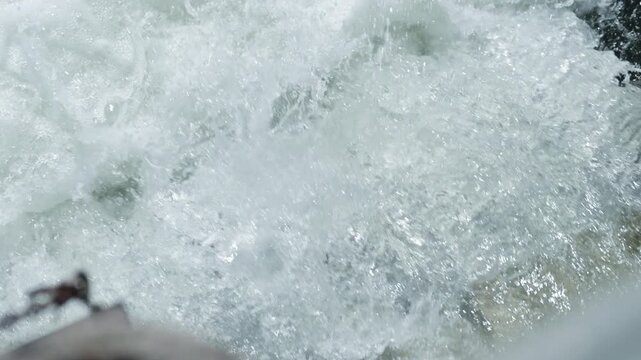 A salmon leaps against the current in the Ganaraska River fish ladder. Slow motion captures the rhythmic muscle contractions and the suspended foam of the rushing water.